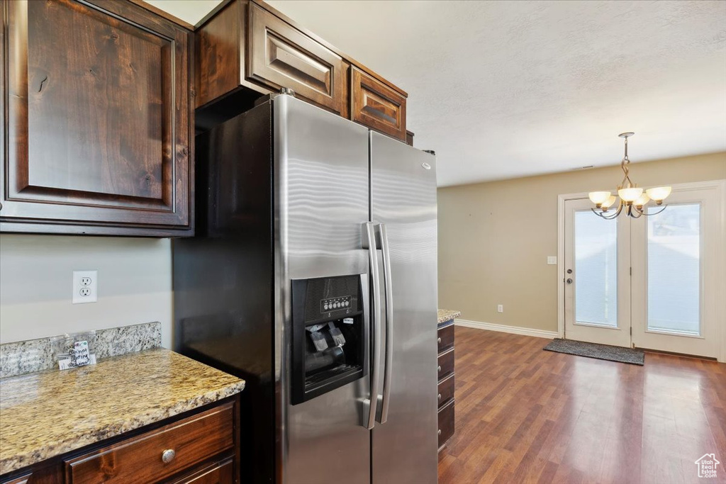 Kitchen with stainless steel fridge with ice dispenser, dark wood-type flooring, a chandelier, and dark brown cabinetry