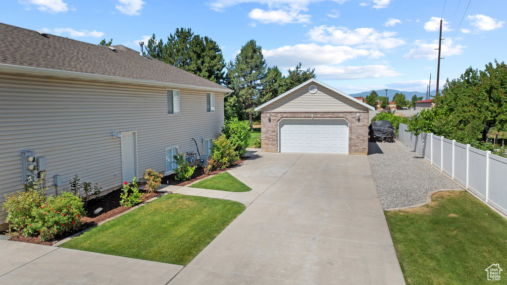 View of side of home featuring a garage, an outdoor structure, a mountain view, and brick siding