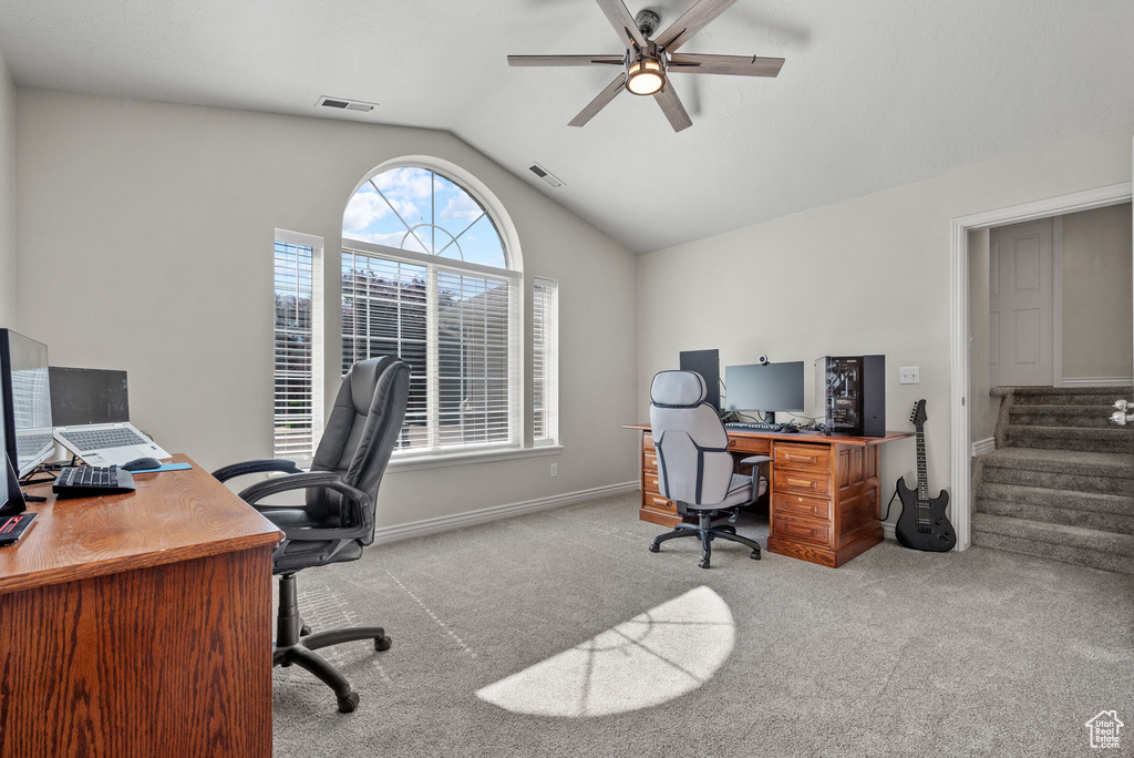 Carpeted home office featuring lofted ceiling and ceiling fan