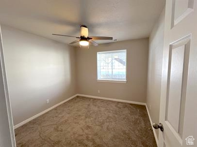 Spare room with carpet flooring and ceiling fan