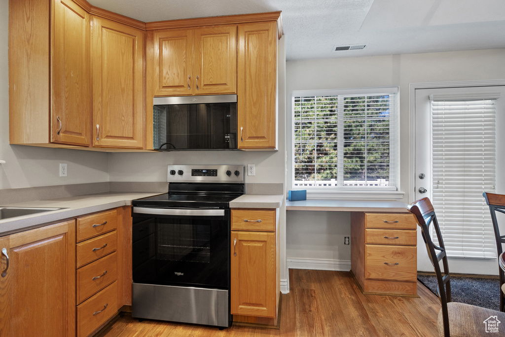 Kitchen featuring stainless steel appliances, light wood finished floors, and light countertops