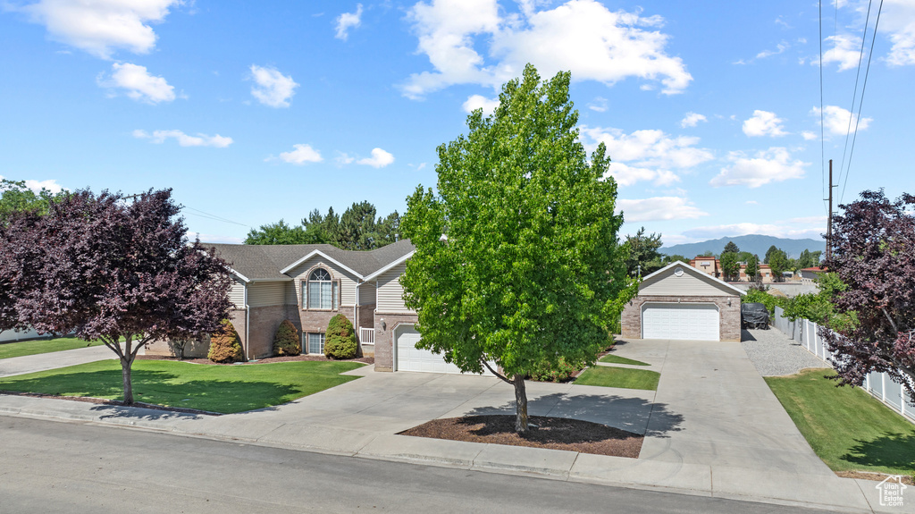 Obstructed view of property with brick siding, a garage, and concrete driveway