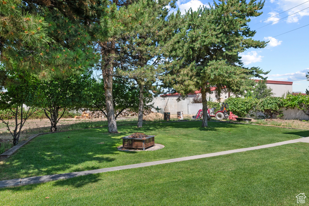 View of green lawn featuring a fire pit