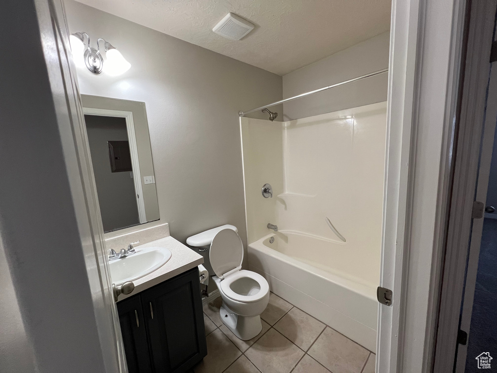 Full bath featuring tile patterned flooring, vanity, shower / bathtub combination, a textured ceiling, and electric panel