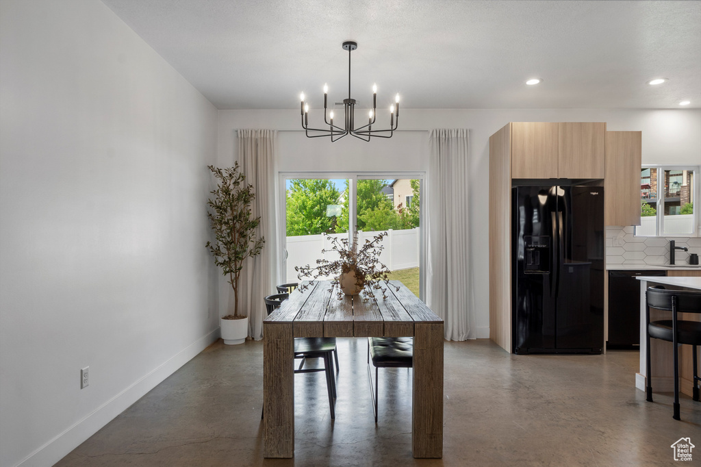 Dining area featuring plenty of natural light, a chandelier, recessed lighting, and finished concrete flooring