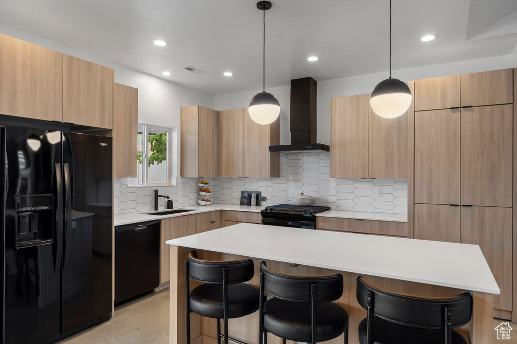 Kitchen with black appliances, modern cabinets, wall chimney exhaust hood, a kitchen breakfast bar, and decorative backsplash
