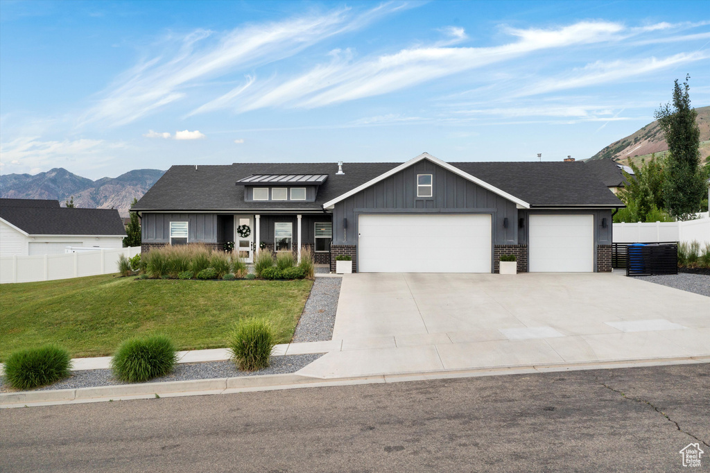 View of front of house featuring an attached garage, board and batten siding, driveway, and a mountain view