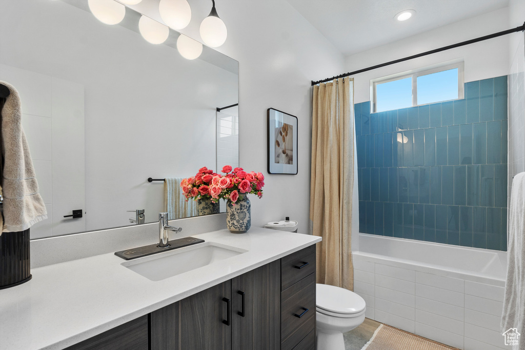 Bathroom featuring tiled shower / bath combo, vanity, and tile patterned floors
