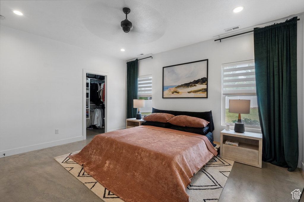 Bedroom featuring multiple windows, recessed lighting, a walk in closet, ceiling fan, and a closet
