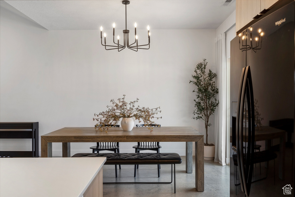 Dining area with a chandelier and finished concrete floors