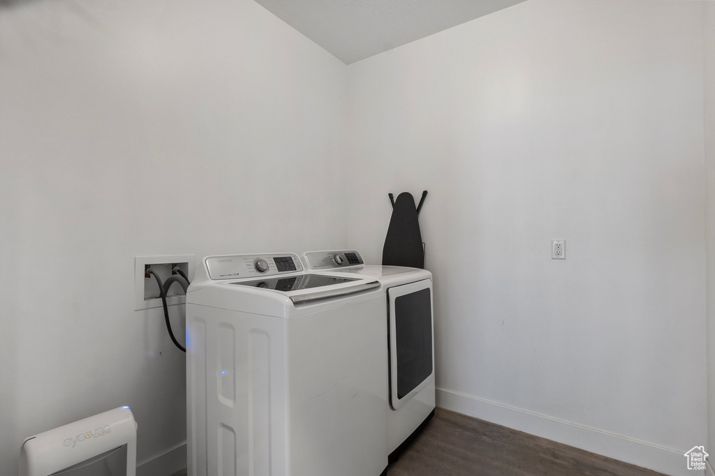 Laundry area featuring independent washer and dryer and dark wood finished floors