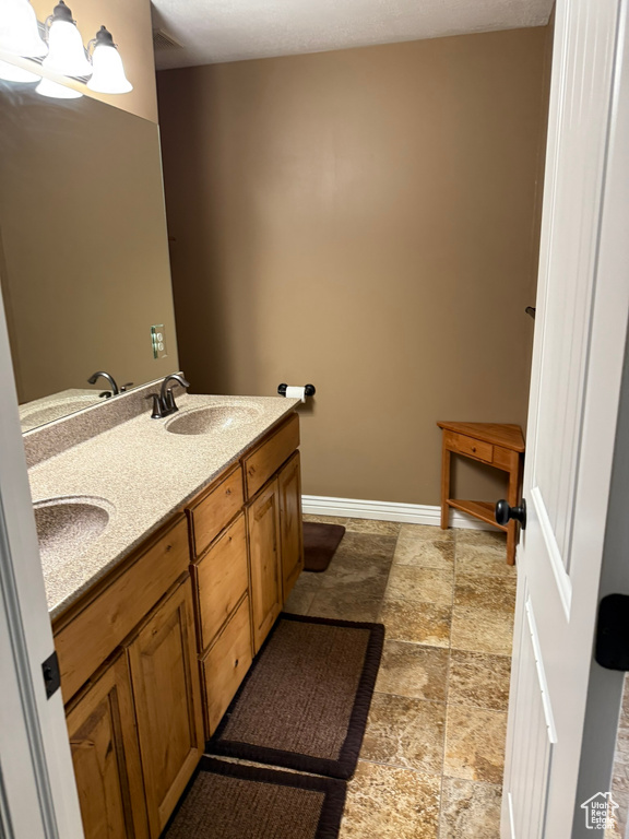 Full bath with double vanity and stone finish flooring
