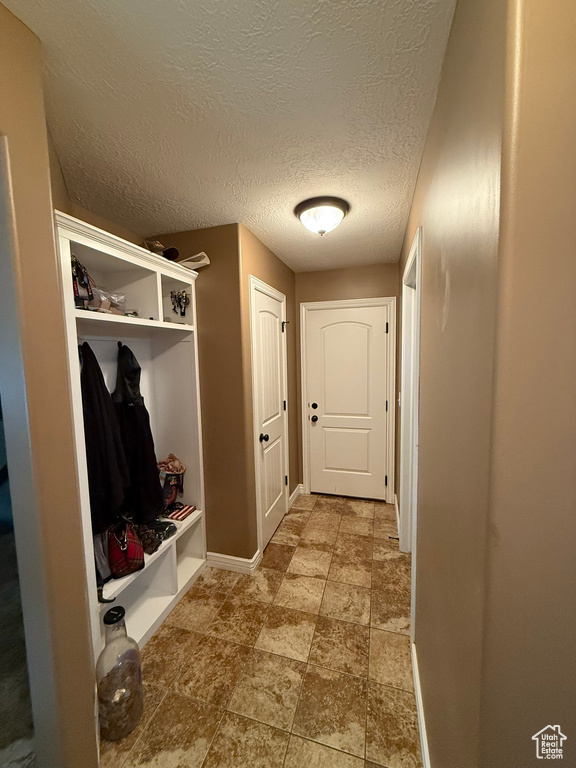 Mudroom with a textured ceiling and stone finish floors
