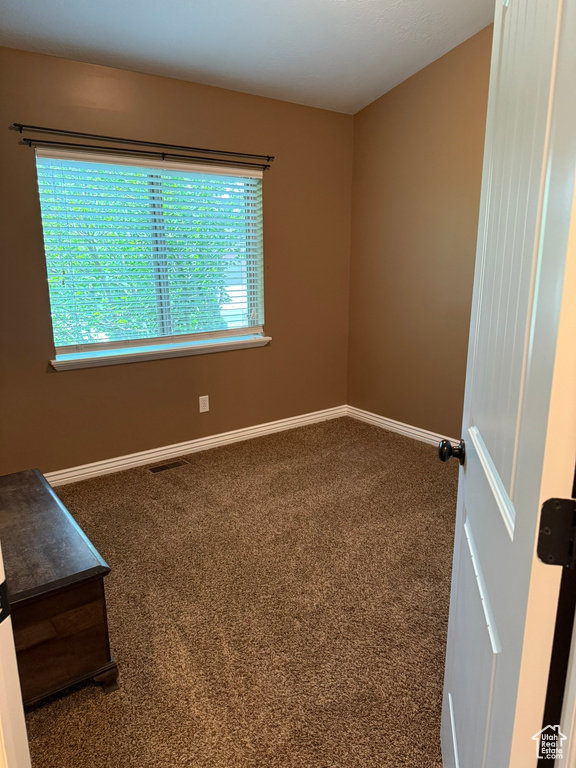 Carpeted spare room with baseboards