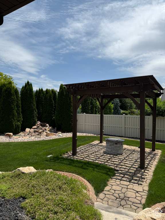 View of yard with a fire pit, a pergola, and a patio