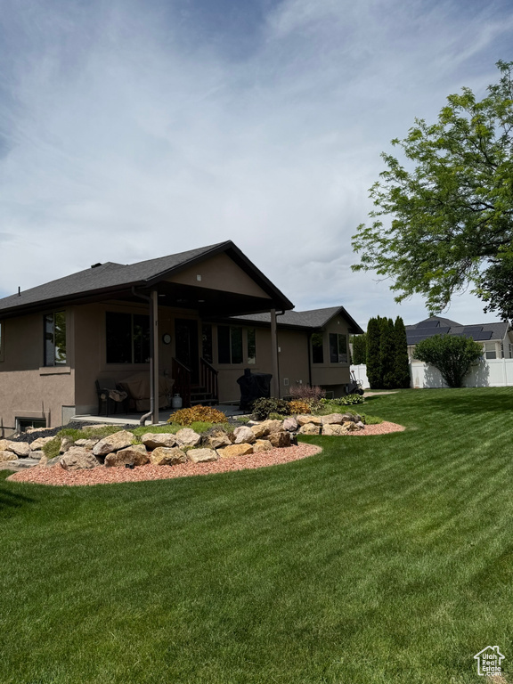 Rear view of house with stucco siding and a patio area