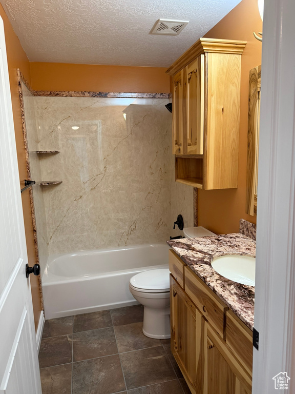 Bathroom with vanity, washtub / shower combination, and a textured ceiling