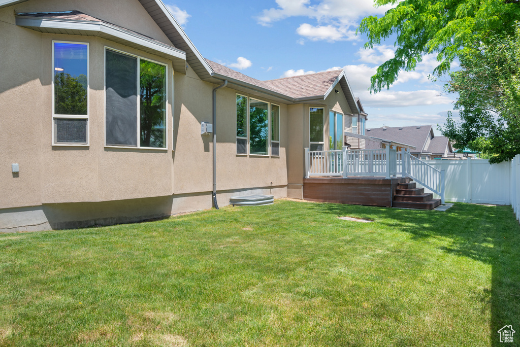 View of property exterior with stucco siding and a wooden deck