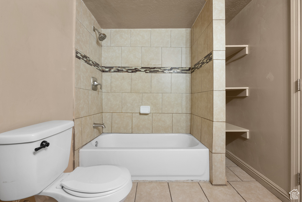 Bathroom with tile patterned floors and shower / washtub combination