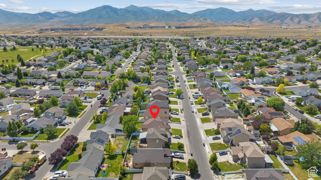 Aerial overview of property's location with nearby suburban area and a mountainous background