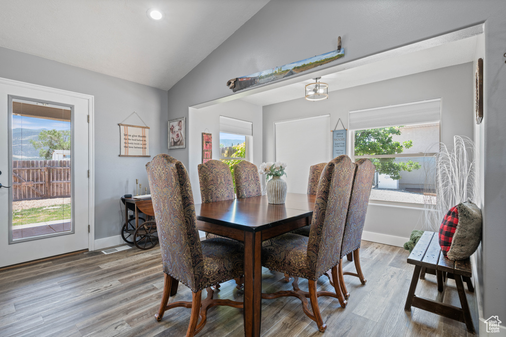 Dining area featuring vaulted ceiling, light wood-style flooring, and recessed lighting