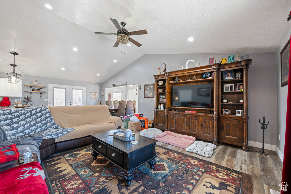 Living room with a ceiling fan, lofted ceiling, wood finished floors, and recessed lighting