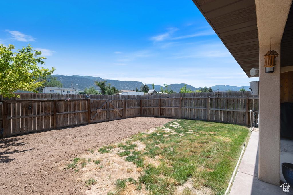 Fenced yard featuring a mountain view