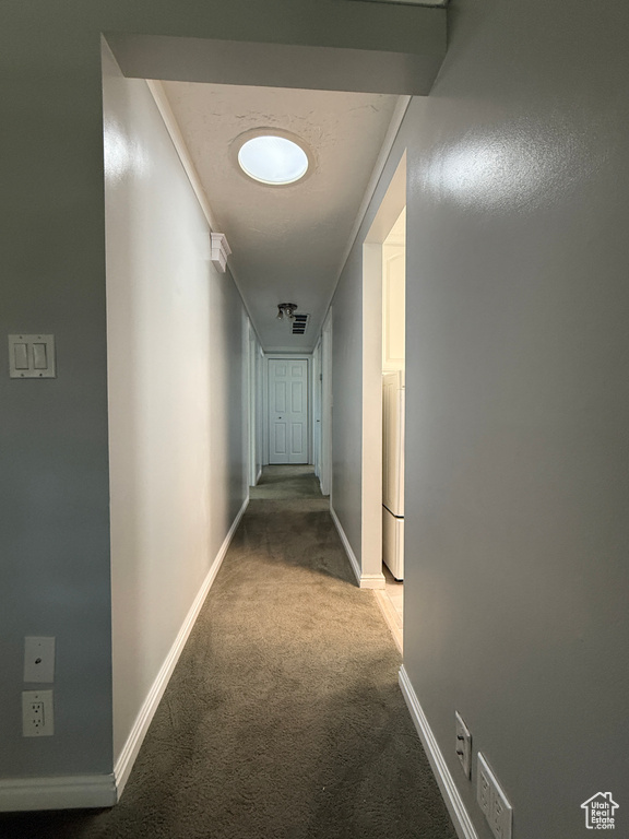 Hall featuring light colored carpet and baseboards