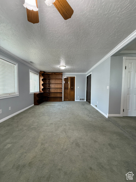 Unfurnished living room with a textured ceiling, carpet flooring, and ornamental molding