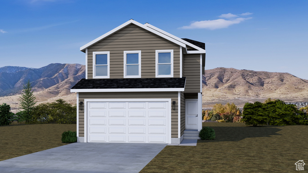 Traditional home with a mountain view, driveway, a front yard, and an attached garage