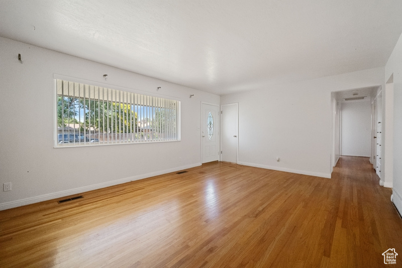 Empty room featuring plenty of natural light and light wood-type flooring