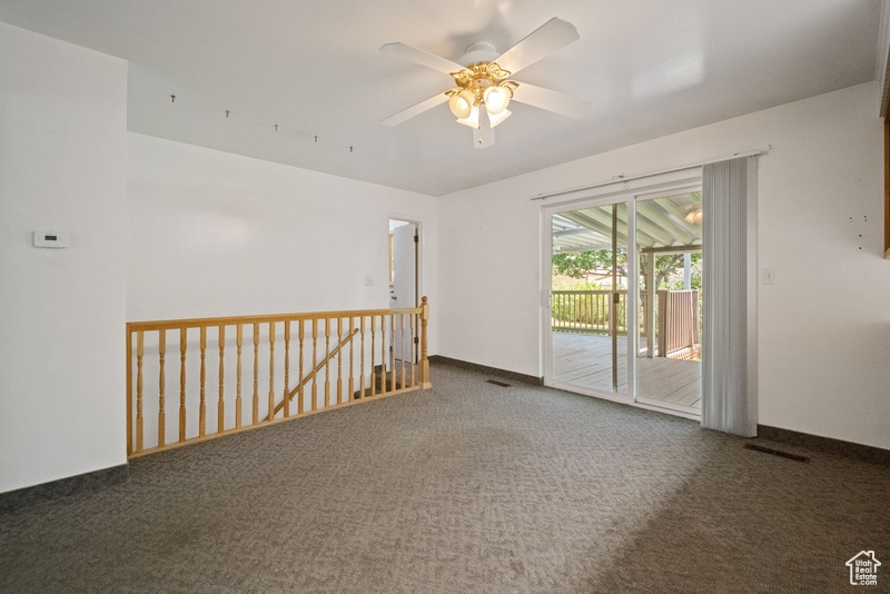 Carpeted spare room featuring ceiling fan