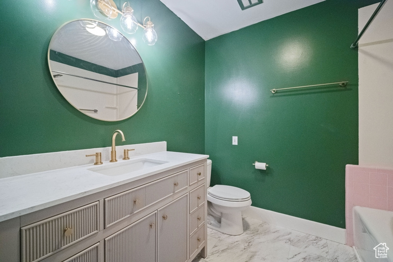 Bathroom with a bath, vanity, and marble finish flooring