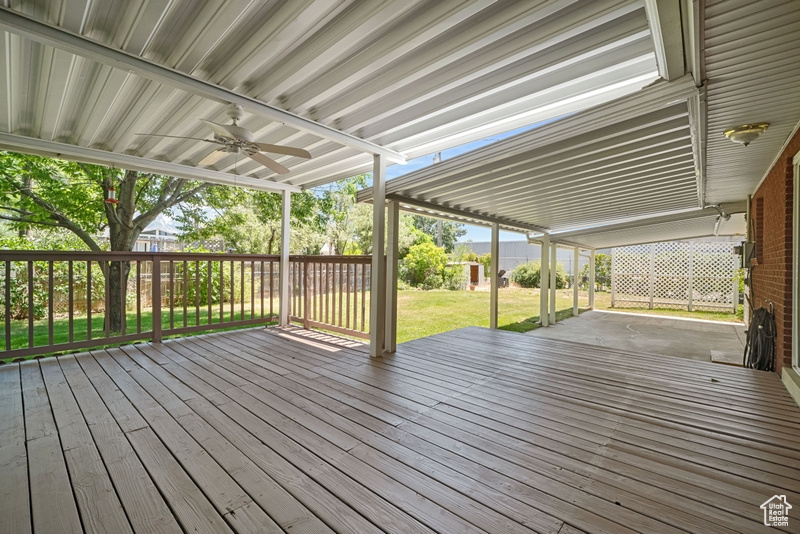 Wooden deck featuring ceiling fan and a lawn