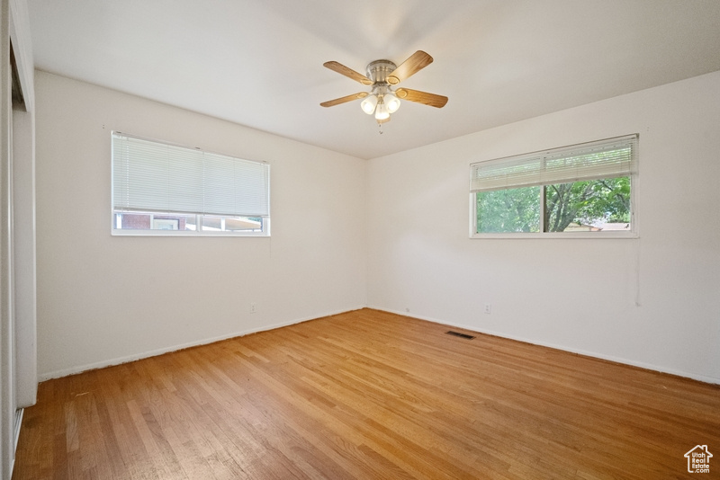 Spare room featuring light wood-style flooring and ceiling fan