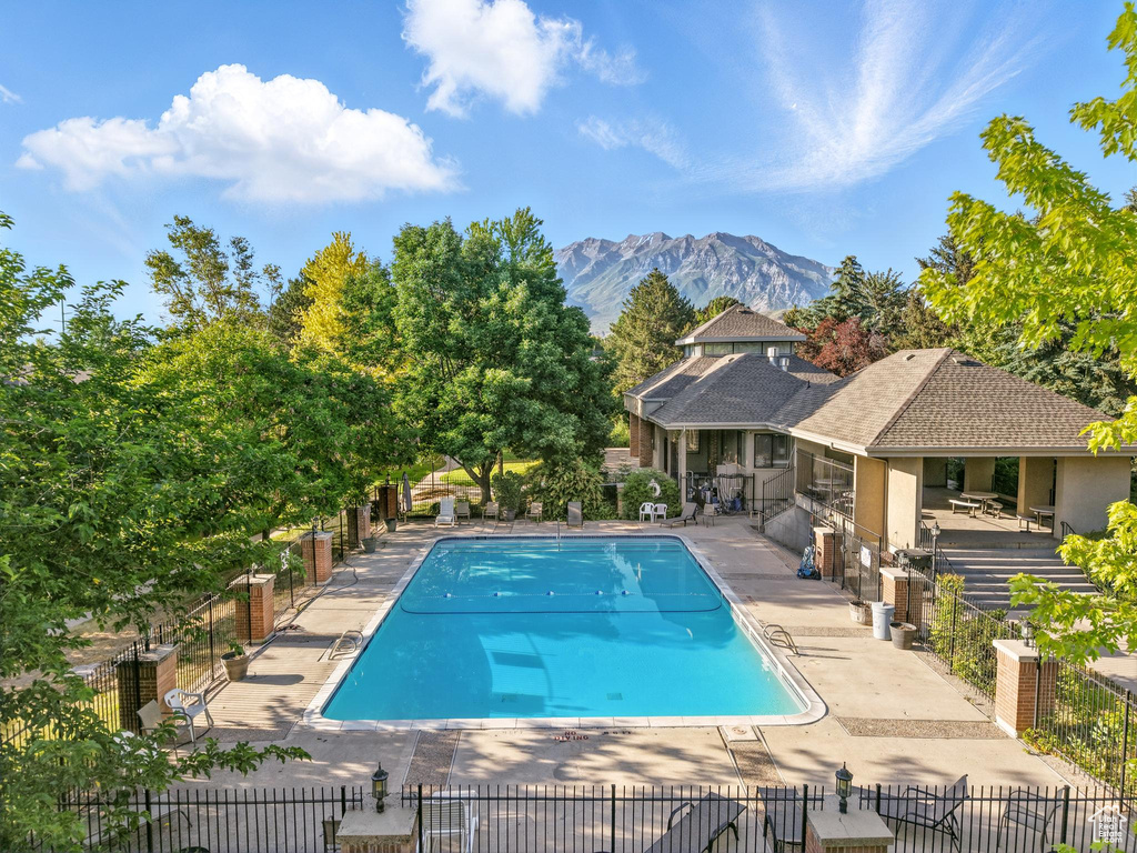 Community pool featuring a mountain view and a patio area