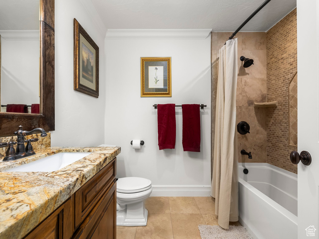 Full bath with vanity, shower / bath combination with curtain, tile patterned floors, and ornamental molding