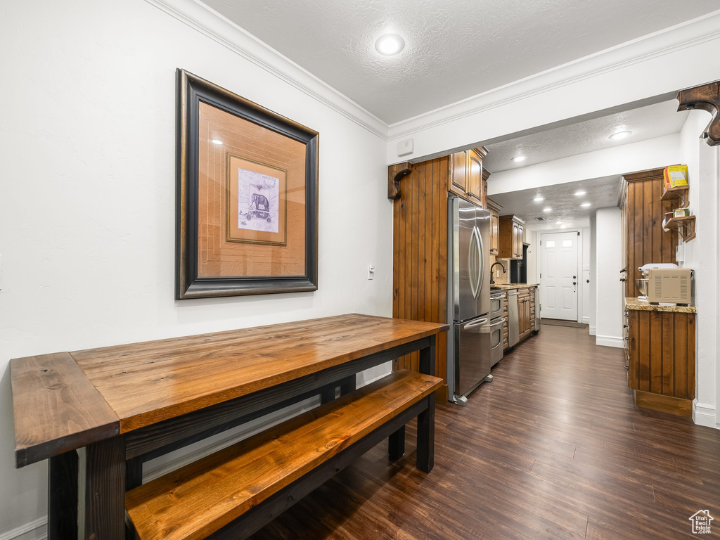 Dining area featuring recessed lighting, ornamental molding, and dark wood-type flooring