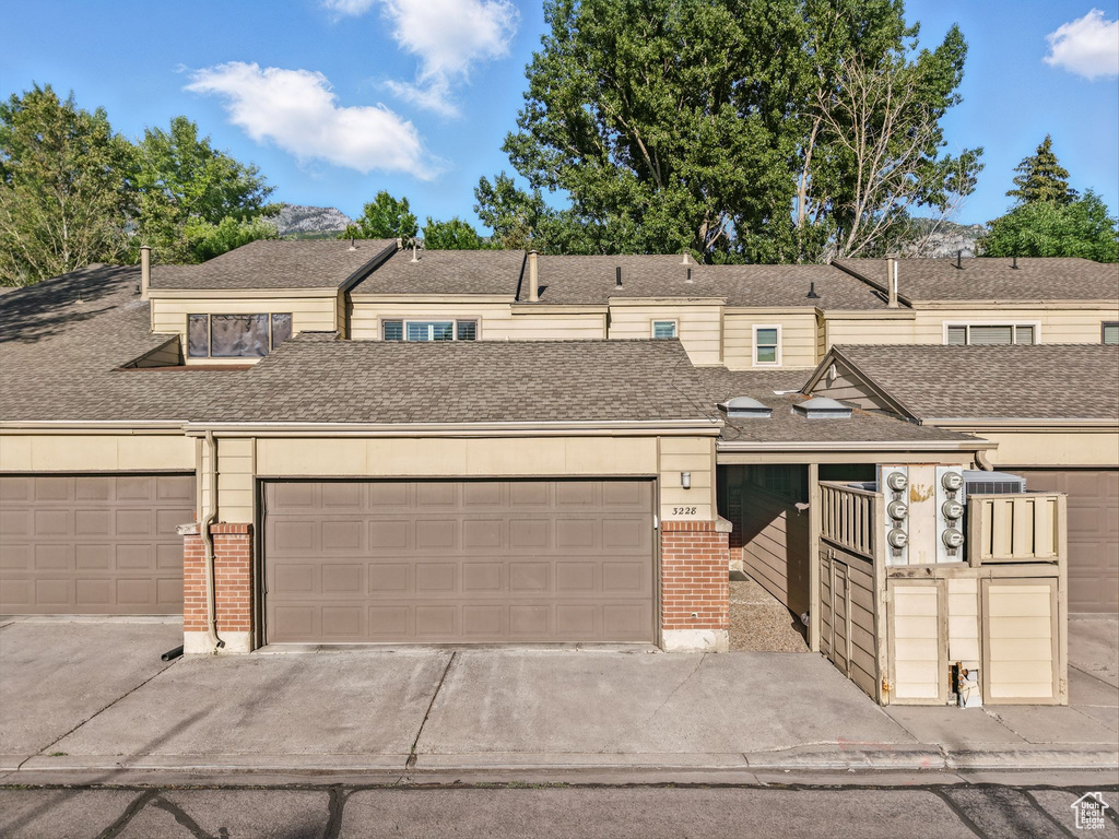 Multi unit property featuring brick siding and roof with shingles