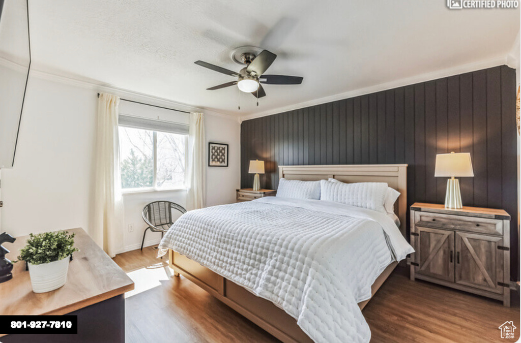 Bedroom with wood finished floors, crown molding, and a ceiling fan