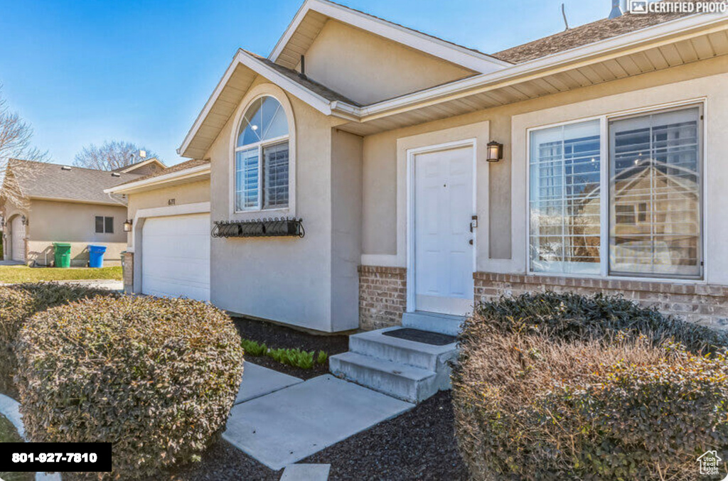 Property entrance with stucco siding and a garage
