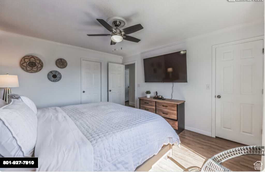 Bedroom with wood finished floors, ornamental molding, and a ceiling fan