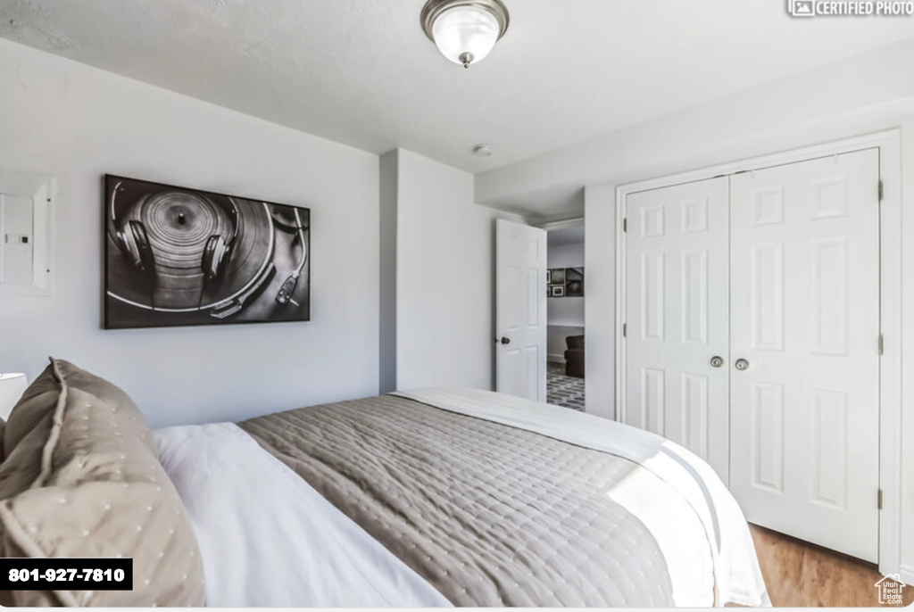 Bedroom with wood finished floors and a closet