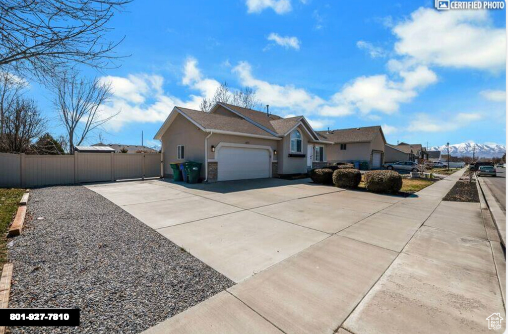 View of front facade featuring driveway, stucco siding, and an attached garage