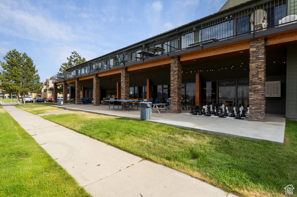 View of property's community with a lawn and a patio