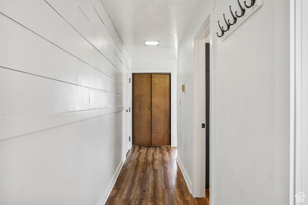 Hall featuring dark wood finished floors and baseboards