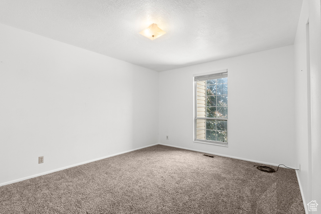 Carpeted empty room featuring baseboards