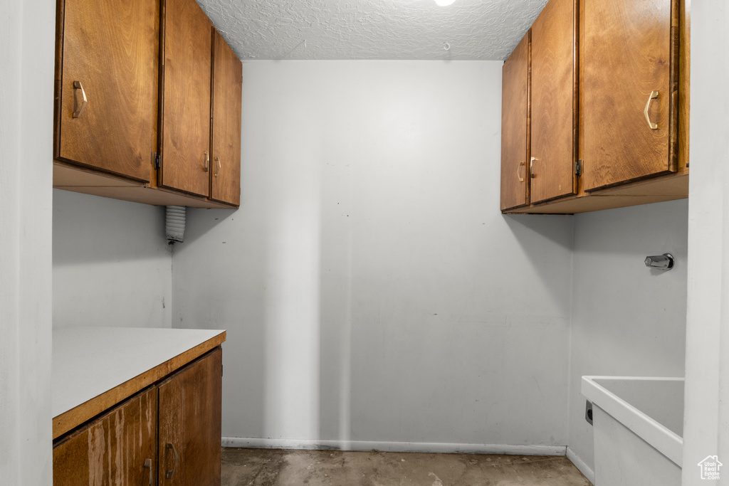 Laundry area with a textured ceiling and hookup for an electric dryer