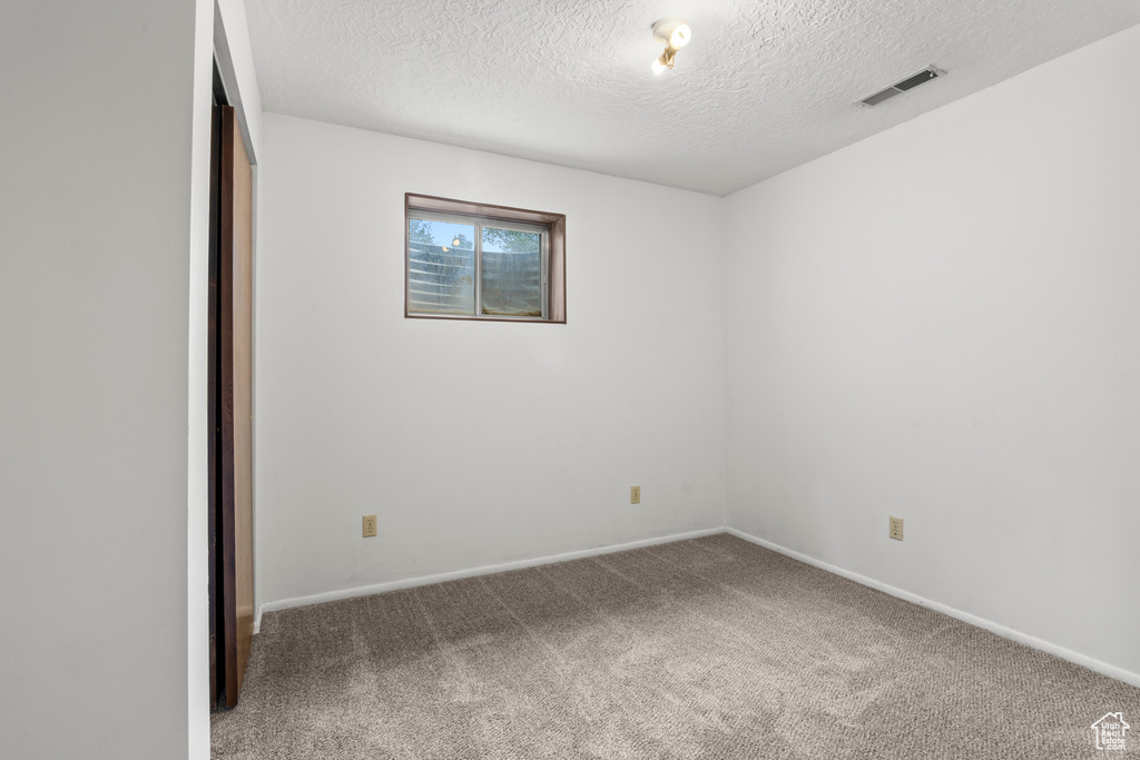 Unfurnished bedroom with carpet flooring, a textured ceiling, and a closet