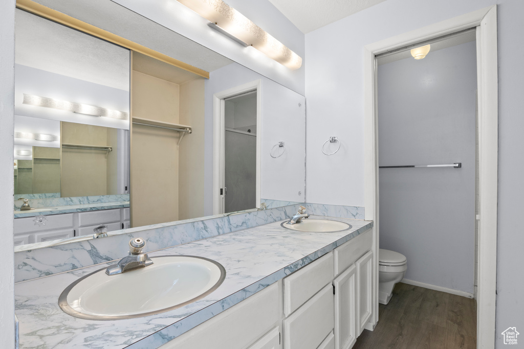Bathroom with double vanity and wood finished floors
